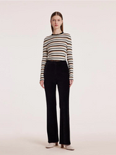 a lady in striped sweater with black straight leg pants